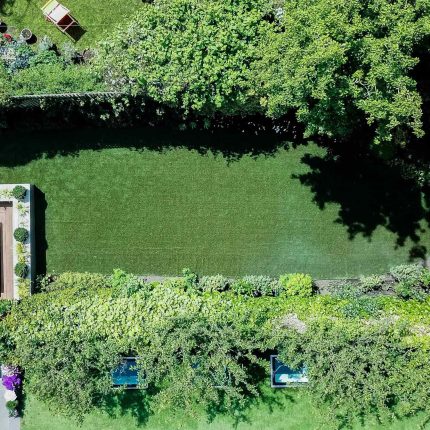 A family garden with terrace constructed with Design Clad from London Stone and VistaGreen artificial green wall panels to enhance a small well-loved garden.