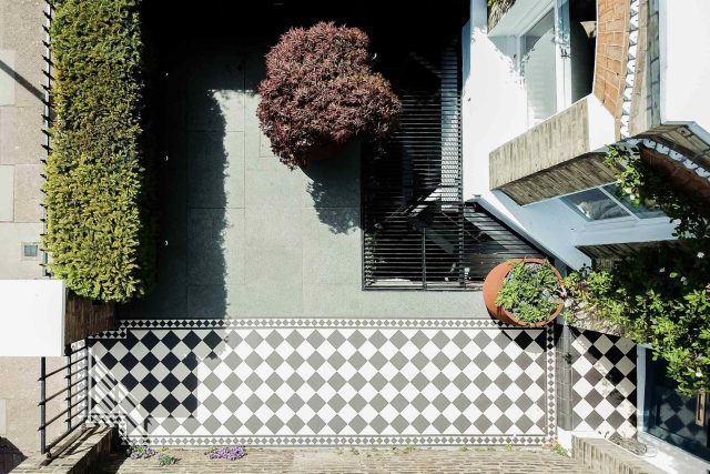 A family garden with terrace constructed with Design Clad from London Stone and VistaGreen artificial green wall panels to enhance a small well-loved garden.