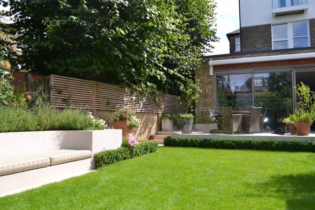 Lovely low maintenance family garden in Putney with raised bed for herbs and edible / culinary plants garden landscape design building company southwest London.