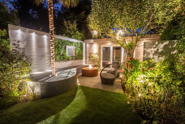 A family garden with terrace constructed with Design Clad from London Stone and VistaGreen artificial green wall panels to enhance a small well-loved garden.