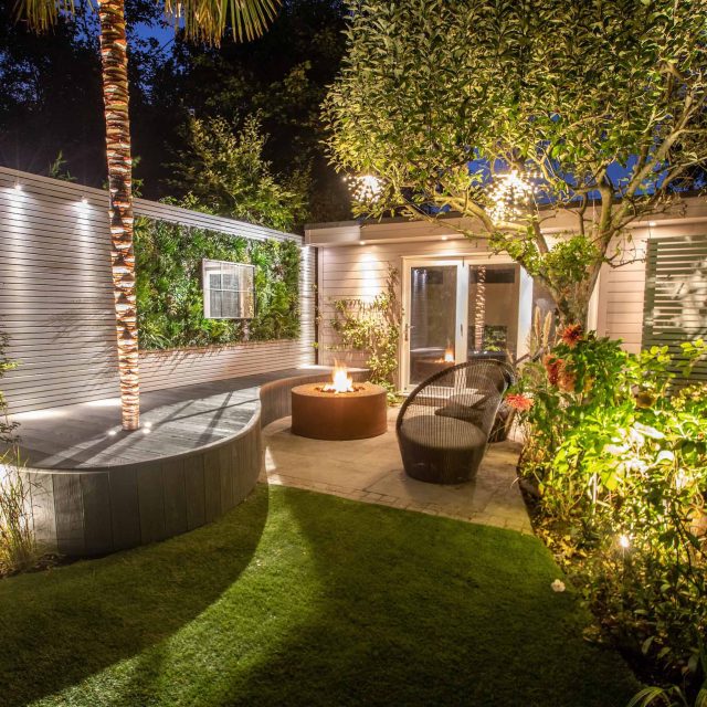 A family garden with terrace constructed with Design Clad from London Stone and VistaGreen artificial green wall panels to enhance a small well-loved garden.