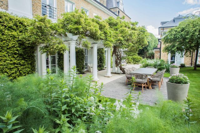 A grand residential garden in Fulham designed and built by The Garden Builders, a relaxing family garden, terrace for fun, outdoor entertainment space with lawn.