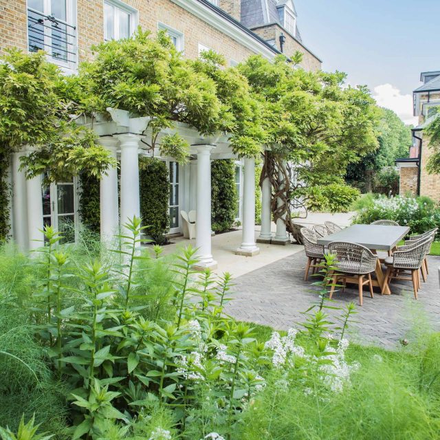 A grand residential garden in Fulham designed and built by The Garden Builders, a relaxing family garden, terrace for fun, outdoor entertainment space with lawn.