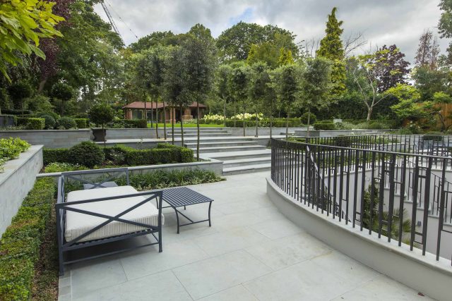 Large contemporary sophisticated garden elegant with multi-level features and staircases to the main terrace outdoor environment a stately, formal look feel.