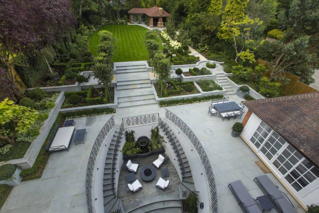Large contemporary sophisticated garden elegant with multi-level features and staircases to the main terrace outdoor environment a stately, formal look feel.