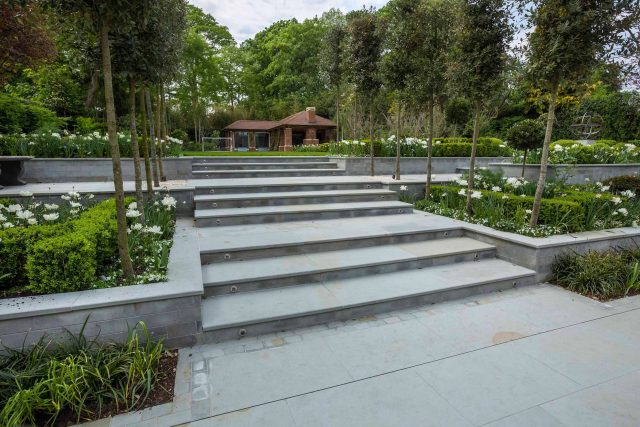 Large contemporary sophisticated garden elegant with multi-level features and staircases to the main terrace outdoor environment a stately, formal look feel.