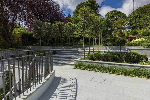 Large contemporary sophisticated garden elegant with multi-level features and staircases to the main terrace outdoor environment a stately, formal look feel.
