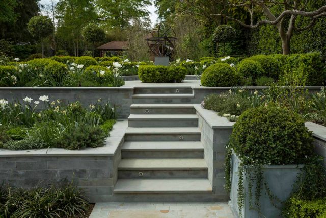 Large contemporary sophisticated garden elegant with multi-level features and staircases to the main terrace outdoor environment a stately, formal look feel.