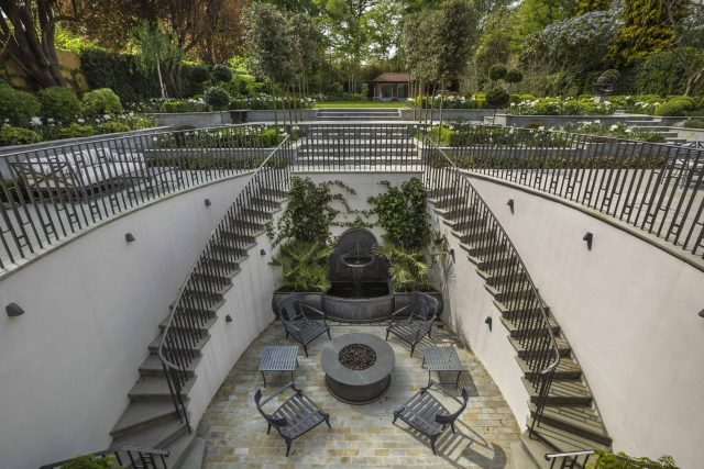 Large contemporary sophisticated garden elegant with multi-level features and staircases to the main terrace outdoor environment a stately, formal look feel.