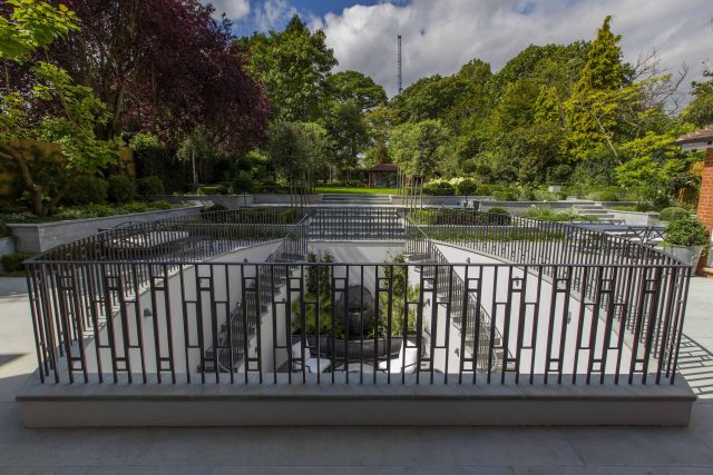 Large contemporary sophisticated garden elegant with multi-level features and staircases to the main terrace outdoor environment a stately, formal look feel.