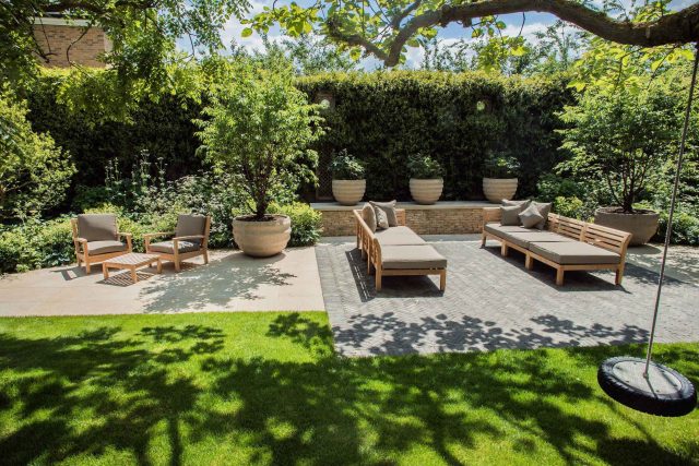 A grand residential garden in Fulham designed and built by The Garden Builders, a relaxing family garden, terrace for fun, outdoor entertainment space with lawn.