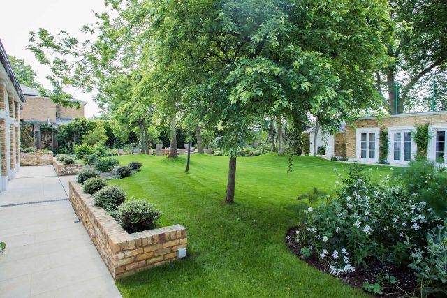 A grand residential garden in Fulham designed and built by The Garden Builders, a relaxing family garden, terrace for fun, outdoor entertainment space with lawn.