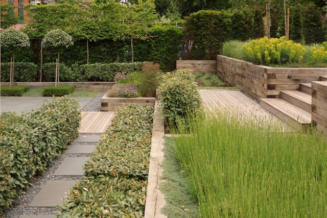 Beautiful town garden in Putney, design Garden landscaping company near me includes black granite stone paving and hard wood gates bespoke gates in hard wood.