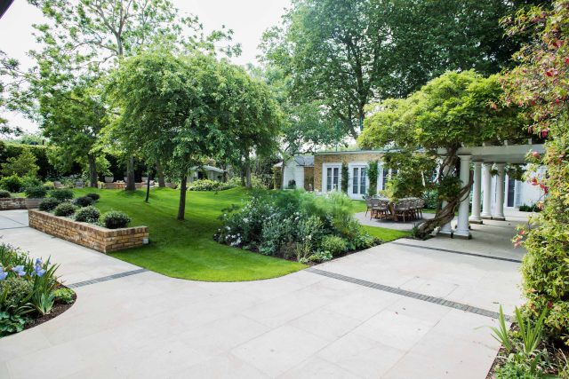A grand residential garden in Fulham designed and built by The Garden Builders, a relaxing family garden, terrace for fun, outdoor entertainment space with lawn.
