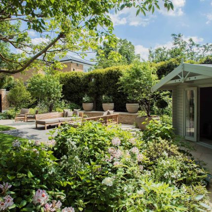 A grand residential garden in Fulham designed and built by The Garden Builders, a relaxing family garden, terrace for fun, outdoor entertainment space with lawn.