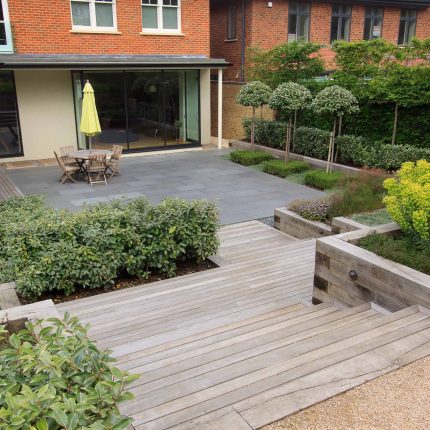 Beautiful town garden in Putney, design Garden landscaping company near me includes black granite stone paving and hard wood gates bespoke gates in hard wood.