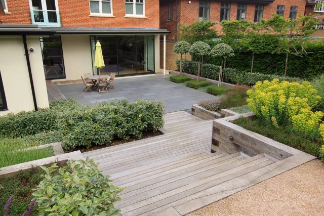 Beautiful town garden in Putney, design Garden landscaping company near me includes black granite stone paving and hard wood gates bespoke gates in hard wood.