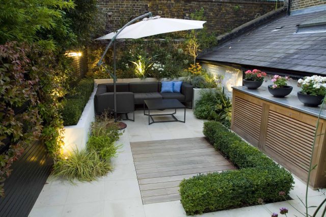 Outdoor room in Sloane Square Chelsea with Gloster exterior furniture and lighting and timber decking, roof terrace designer, sandstone paving raised beds.