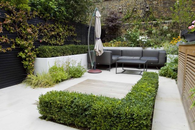 Outdoor room in Sloane Square Chelsea with Gloster exterior furniture and lighting and timber decking, roof terrace designer, sandstone paving raised beds.
