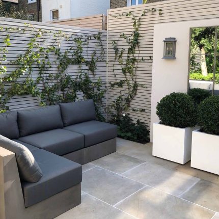 Wandsworth Garden designer initials Artificial Vertical Green Wall toward the rear of the garden breaks up the white of the adjoining trellis and creates space.