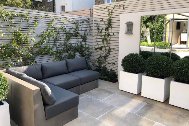 Wandsworth Garden designer initials Artificial Vertical Green Wall toward the rear of the garden breaks up the white of the adjoining trellis and creates space.