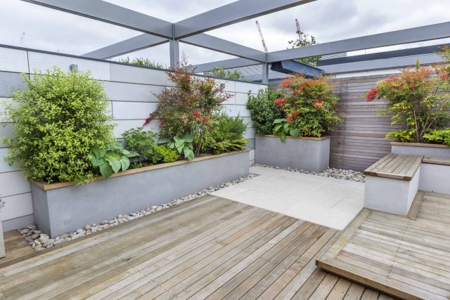 Roof Terrace garden Design for a penthouse apartment King's Cross development, expanse decking storage benches, planters, cedar deck seating area outdoor room.