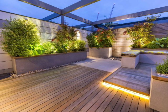 Roof Terrace garden Design for a penthouse apartment King's Cross development, expanse decking storage benches, planters, cedar deck seating area outdoor room.