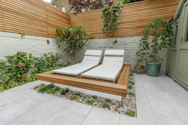 Garden design Vauxhall South London outdoor space, hidden LED strip lighting, polished white pebbles, porcelain paving steps tiles stand slatted cedar trellis.