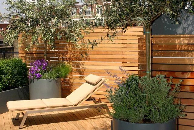 Contemporary Roof Terrace garden designer in Baker Street Marylebone, a stunning water feature curved bench cladded in iroko to create an illusion of space.