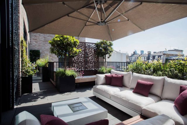Roof terrace design Covent Garden composite decking luxurious entertaining in the heart of London with contemporary furniture a bio-fuel burning fire table.