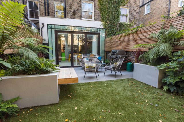 Small, contemporary garden in Islington, designed by Simon Ronan and constructed by The Garden Builders, flanking the terrace are raised beds, floating benches.