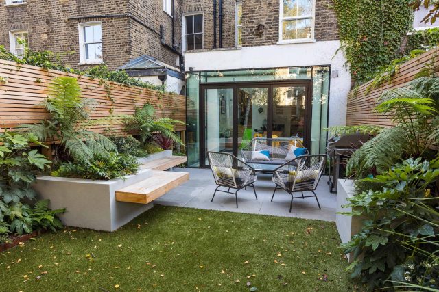 Small, contemporary garden in Islington, designed by Simon Ronan and constructed by The Garden Builders, flanking the terrace are raised beds, floating benches.