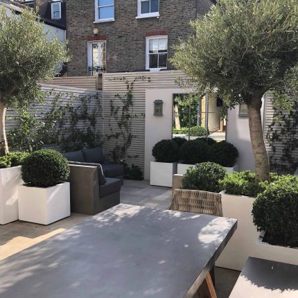 Wandsworth Garden designer initials Artificial Vertical Green Wall toward the rear of the garden breaks up the white of the adjoining trellis and creates space.