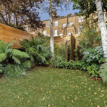 Small, contemporary garden in Islington, designed by Simon Ronan and constructed by The Garden Builders, flanking the terrace are raised beds, floating benches.