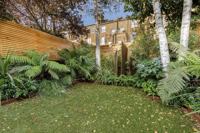 Small, contemporary garden in Islington, designed by Simon Ronan and constructed by The Garden Builders, flanking the terrace are raised beds, floating benches.