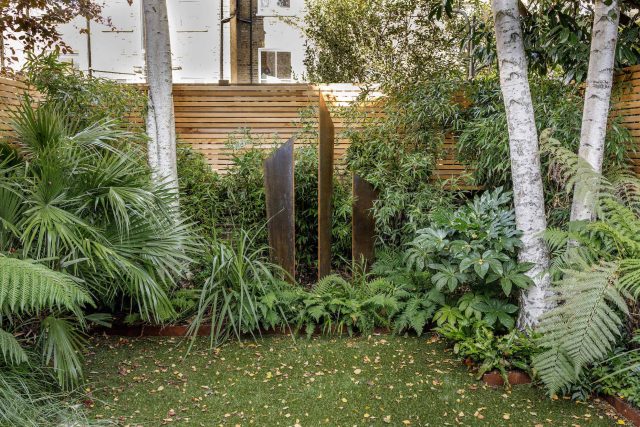 Small, contemporary garden in Islington, designed by Simon Ronan and constructed by The Garden Builders, flanking the terrace are raised beds, floating benches.
