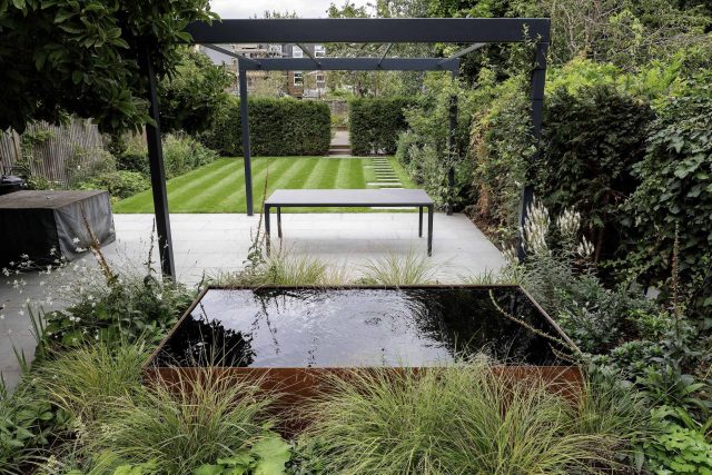 Garden designer contemporary family garden Chiswick friendly space decking, dining table, an aluminum pergola in powder-coated finish, a cozy and warm outlook.
