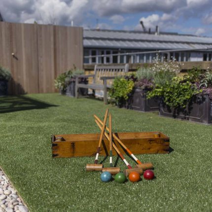 Roof terrace with decking, artificial level lawn and LED lighting design at New Concordia Wharf, highlight surfaces and architectural elements in the evenings.