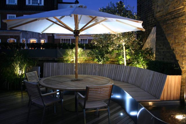 Contemporary Roof Terrace garden designer in Baker Street Marylebone, a stunning water feature curved bench cladded in iroko to create an illusion of space.