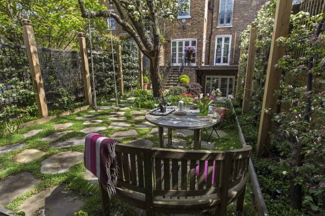 Inspirational city garden design in Holland Park London, Yorkstone stepping stones, oak posts architectural rythm to utilise lower terrace, near the basement.