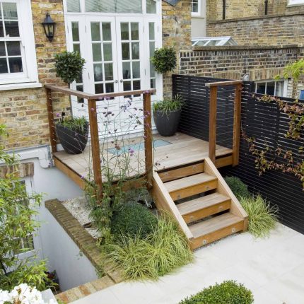 Outdoor room in Sloane Square Chelsea with Gloster exterior furniture and lighting and timber decking, roof terrace designer, sandstone paving raised beds.