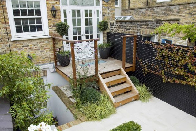 Outdoor room in Sloane Square Chelsea with Gloster exterior furniture and lighting and timber decking, roof terrace designer, sandstone paving raised beds.