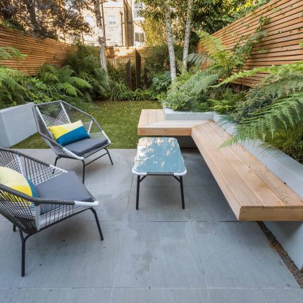 Small, contemporary garden in Islington, designed by Simon Ronan and constructed by The Garden Builders, flanking the terrace are raised beds, floating benches.