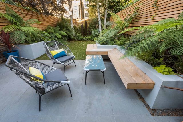 Small, contemporary garden in Islington, designed by Simon Ronan and constructed by The Garden Builders, flanking the terrace are raised beds, floating benches.