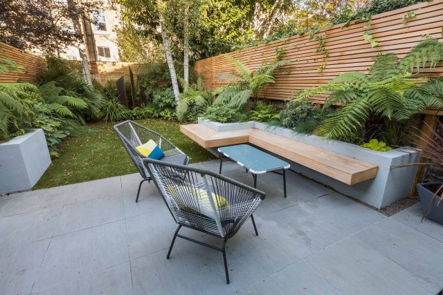 Small, contemporary garden in Islington, designed by Simon Ronan and constructed by The Garden Builders, flanking the terrace are raised beds, floating benches.