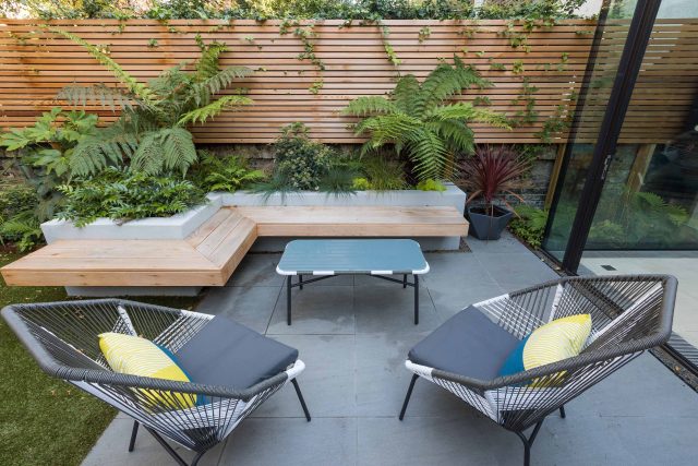 Small, contemporary garden in Islington, designed by Simon Ronan and constructed by The Garden Builders, flanking the terrace are raised beds, floating benches.