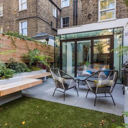 Small, contemporary garden in Islington, designed by Simon Ronan and constructed by The Garden Builders, flanking the terrace are raised beds, floating benches.