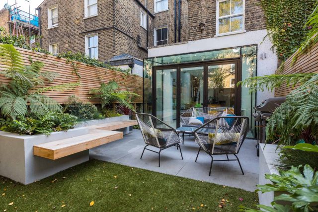 Small, contemporary garden in Islington, designed by Simon Ronan and constructed by The Garden Builders, flanking the terrace are raised beds, floating benches.