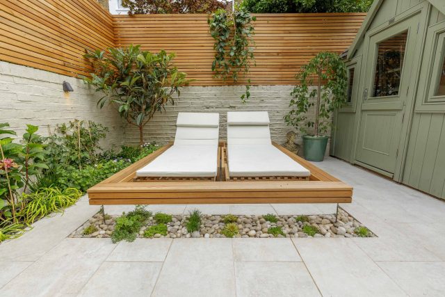 Garden design Vauxhall South London outdoor space, hidden LED strip lighting, polished white pebbles, porcelain paving steps tiles stand slatted cedar trellis.