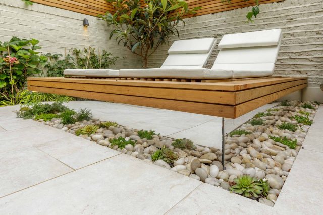 Garden design Vauxhall South London outdoor space, hidden LED strip lighting, polished white pebbles, porcelain paving steps tiles stand slatted cedar trellis.
